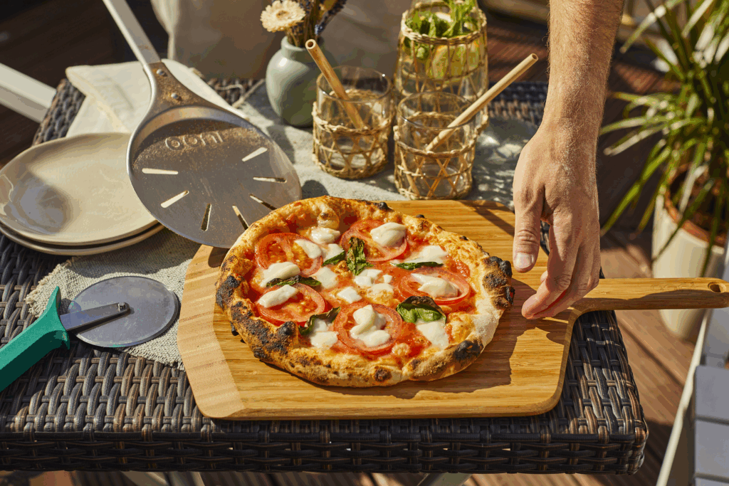 OONI Pizza Margherita frisch serviert – Knusprige neapolitanische Margherita vom OONI Pizzaofen auf Holzbrett