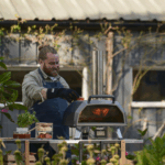 Ooni Karu 2 Pro Pizzaofen im Garten – Mann backt frische Pizza im tragbaren Holz- und Gasofen von Ooni