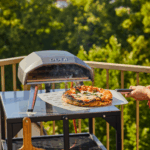 Ooni Koda 12 Gas-Pizzaofen mit frischer Pizza auf der Terrasse