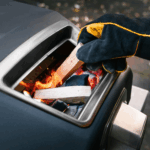 OONI Handschuhe beim Holz nachlegen im Pizzaofen – hitzebeständige Grillhandschuhe im Einsatz