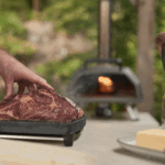 Steakzubereitung vor Ooni Karu 2 Pro Pizzaofen im Garten