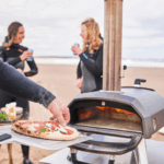 Ooni Karu 2 Pizzaofen am Strand mit frischer Pizza