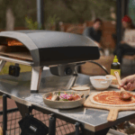 Ooni Koda 2 Pro Schwarz Pizzaofen auf Terrasse beim Zubereiten einer Pizza mit frischen Zutaten
