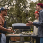 Freunde bereiten Pizza mit dem Ooni Koda 2 Pro Schwarz Gas-Pizzaofen im Garten zu