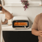 Ooni Volt 12 elektrischer Pizzaofen in Polareweiß mit frisch gebackener Pizza in moderner Küche