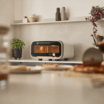 Moderner Ooni Volt 12 Elektro Pizzaofen auf Küchenarbeitsplatte mit Pflanzen und Deko im Hintergrund – ideal für authentische Pizza zuhause.