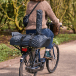 Person transportiert Ooni Karu 12 im wetterfesten Tragetaschen-Set auf dem Fahrrad – mobil und flexibel unterwegs